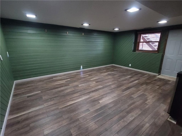 unfurnished room with wood-type flooring and wood walls