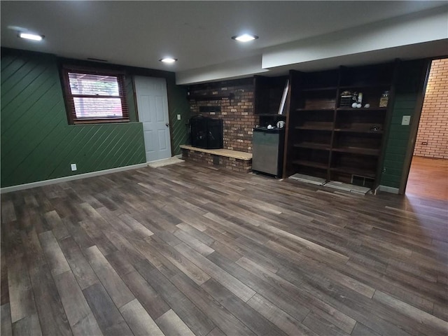 basement with wooden walls and dark wood-type flooring