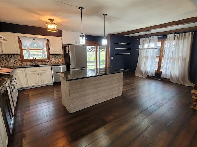 kitchen featuring dark hardwood / wood-style floors, white cabinetry, appliances with stainless steel finishes, and tasteful backsplash