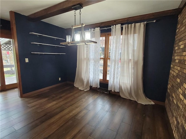 unfurnished dining area featuring brick wall, dark wood-type flooring, and a wealth of natural light