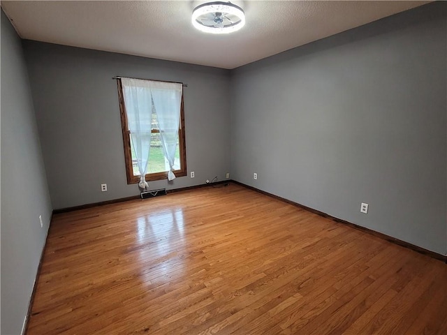 spare room featuring a textured ceiling and light wood-type flooring