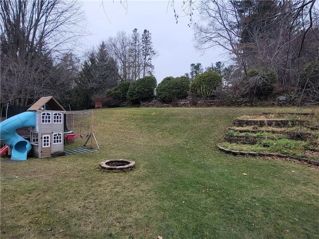 view of yard with a playground and an outdoor fire pit