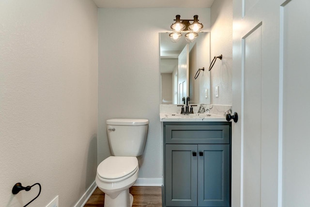 bathroom with wood-type flooring, vanity, and toilet