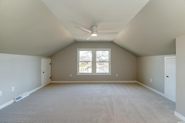 additional living space with ceiling fan, light colored carpet, and lofted ceiling