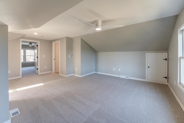 additional living space featuring ceiling fan, light colored carpet, and lofted ceiling