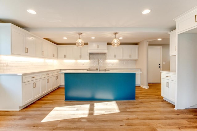 kitchen featuring white cabinetry, hanging light fixtures, and sink