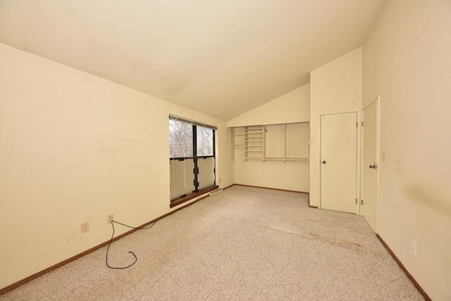 carpeted spare room with lofted ceiling