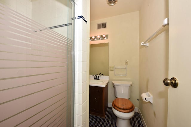 bathroom featuring tile patterned flooring, vanity, toilet, and an enclosed shower