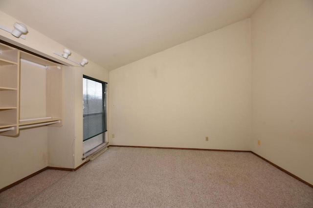 spare room with light colored carpet and lofted ceiling