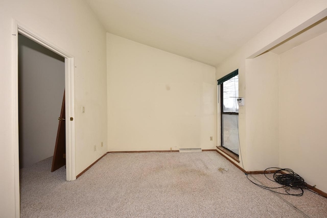 spare room with light carpet and vaulted ceiling