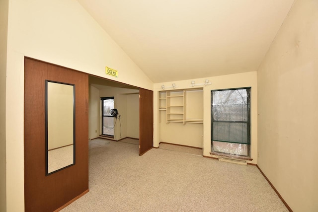 carpeted spare room featuring lofted ceiling