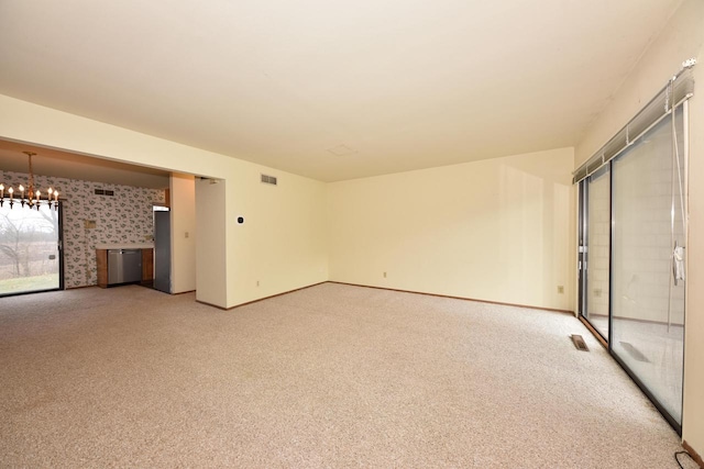 carpeted empty room with a chandelier