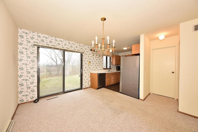 kitchen with stainless steel refrigerator, sink, an inviting chandelier, black dishwasher, and decorative light fixtures