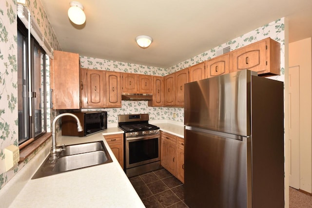 kitchen with sink, dark tile patterned floors, and stainless steel appliances