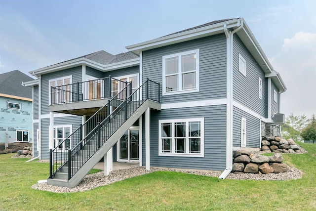 rear view of property featuring a lawn and a wooden deck