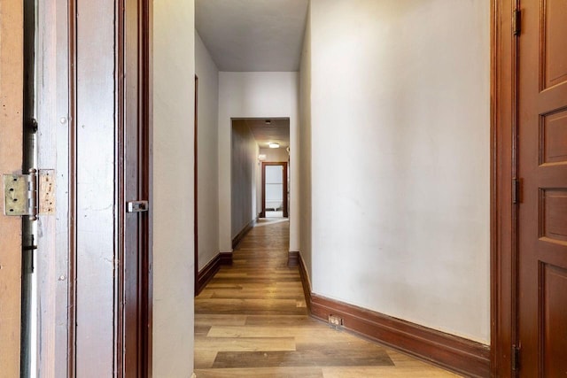 hallway with light hardwood / wood-style floors