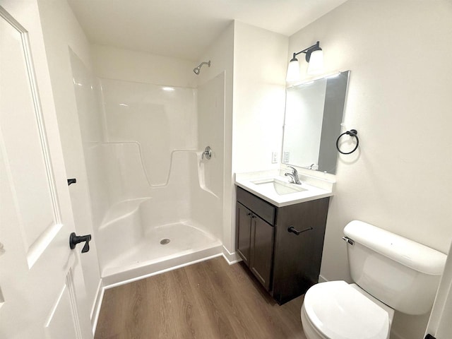 bathroom featuring vanity, hardwood / wood-style flooring, toilet, and walk in shower