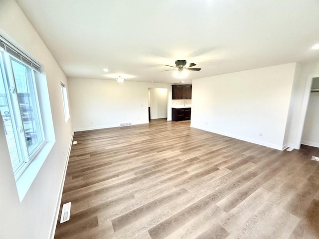 unfurnished living room with wood-type flooring and ceiling fan