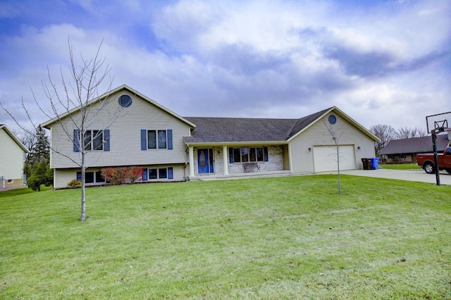 tri-level home with covered porch, a garage, and a front lawn