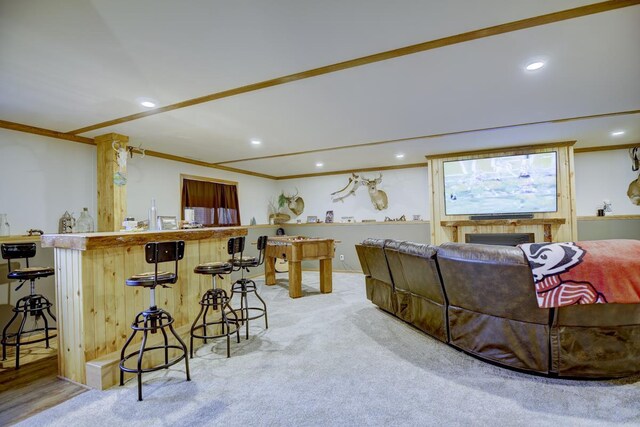 living room featuring light colored carpet, crown molding, and bar area