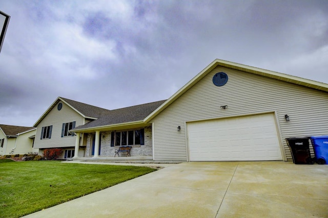 view of front of home with a front lawn, covered porch, and a garage