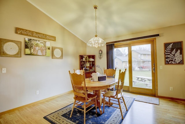 dining room featuring high vaulted ceiling, ornamental molding, a notable chandelier, and hardwood / wood-style flooring