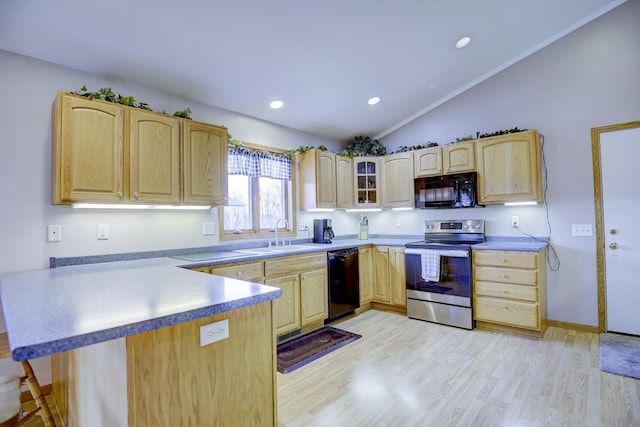 kitchen with lofted ceiling, black appliances, sink, light wood-type flooring, and kitchen peninsula