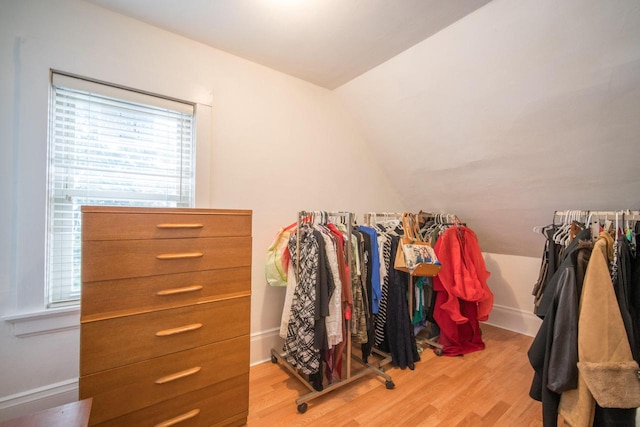 spacious closet featuring light hardwood / wood-style floors and vaulted ceiling