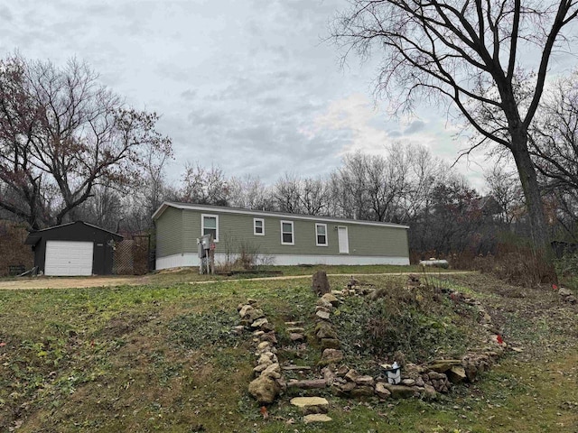 exterior space featuring a garage, a front lawn, and an outdoor structure