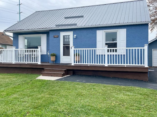 back of house with a lawn and covered porch