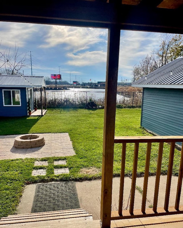 view of yard featuring a patio area, an outdoor structure, and an outdoor fire pit