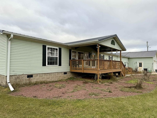 rear view of house with a lawn and a wooden deck