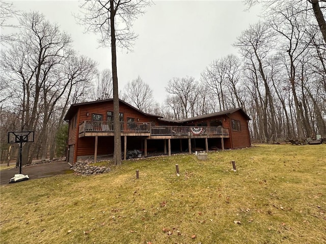 back of property with a lawn and a wooden deck