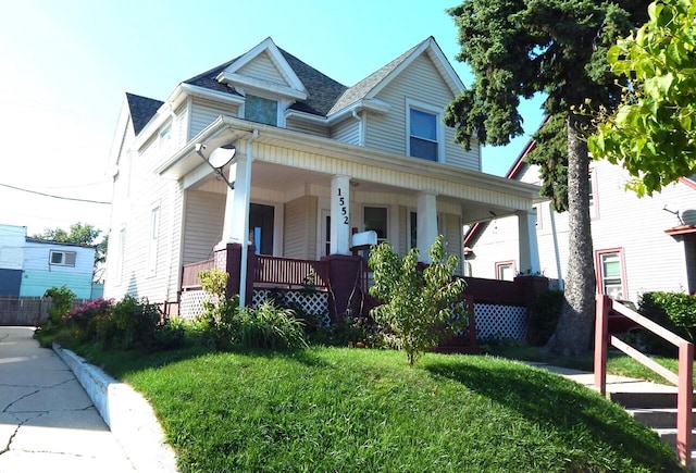 view of front of property featuring covered porch and a front yard