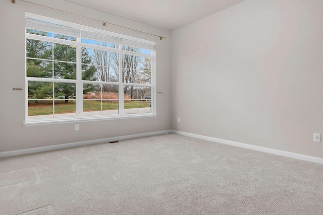 carpeted spare room featuring a healthy amount of sunlight