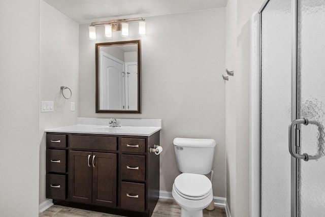 bathroom with an enclosed shower, vanity, and toilet