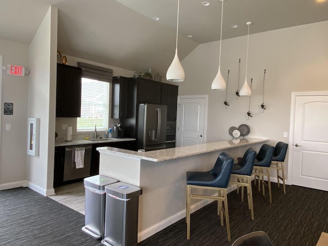 kitchen with kitchen peninsula, appliances with stainless steel finishes, sink, hanging light fixtures, and lofted ceiling