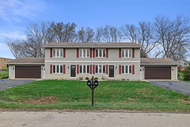 colonial-style house featuring a garage and a front lawn