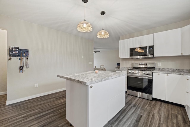 kitchen featuring dark hardwood / wood-style flooring, a kitchen island, white cabinets, and appliances with stainless steel finishes