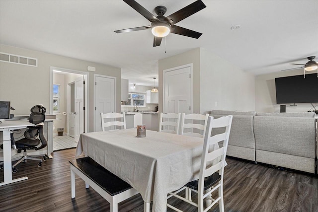 dining room with ceiling fan, sink, and dark hardwood / wood-style floors