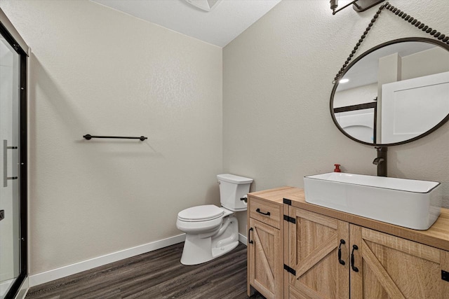 bathroom with toilet, vanity, lofted ceiling, and hardwood / wood-style flooring