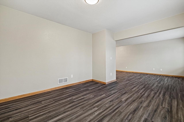 unfurnished room featuring dark wood-type flooring