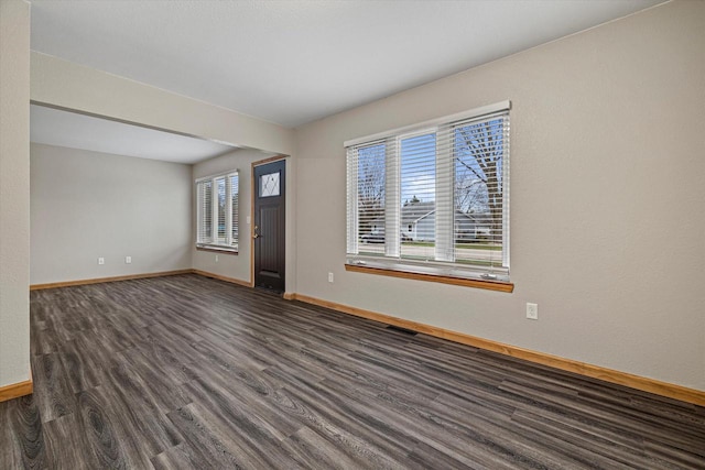 unfurnished room featuring dark hardwood / wood-style flooring and a wealth of natural light