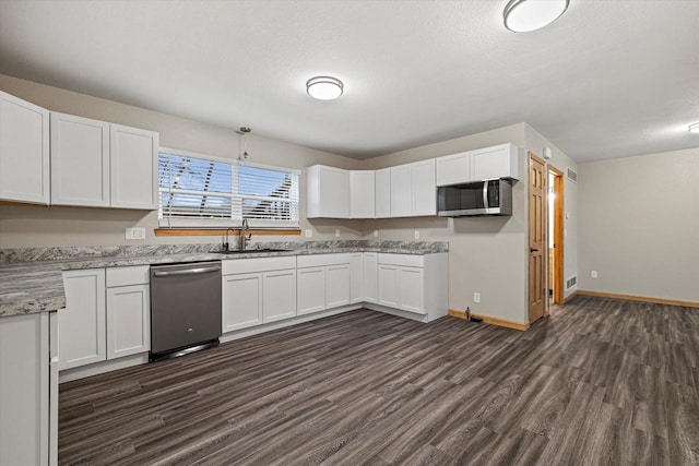 kitchen with dark hardwood / wood-style flooring, white cabinetry, sink, and appliances with stainless steel finishes