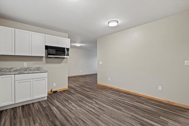 kitchen with dark hardwood / wood-style floors, white cabinetry, and a textured ceiling