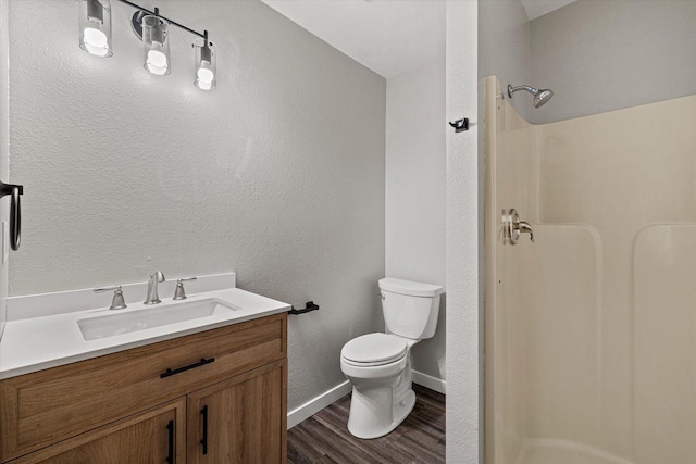 bathroom featuring a shower, vanity, hardwood / wood-style flooring, and toilet