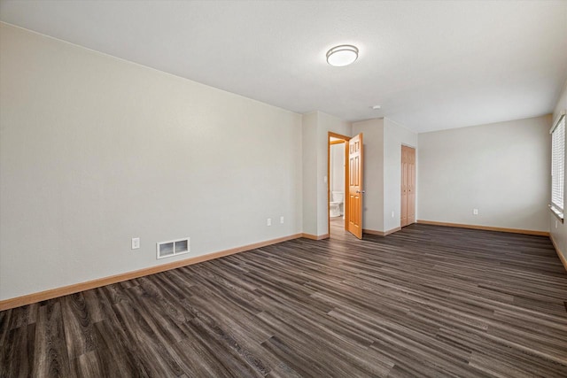 spare room with dark wood-type flooring