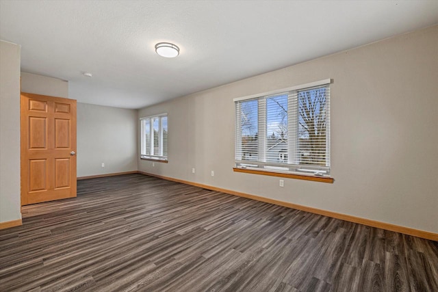 spare room with dark wood-type flooring and a textured ceiling