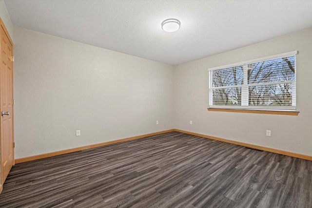 unfurnished room featuring dark wood-type flooring