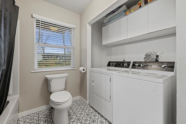 clothes washing area featuring a textured ceiling, washer and clothes dryer, and light tile patterned flooring